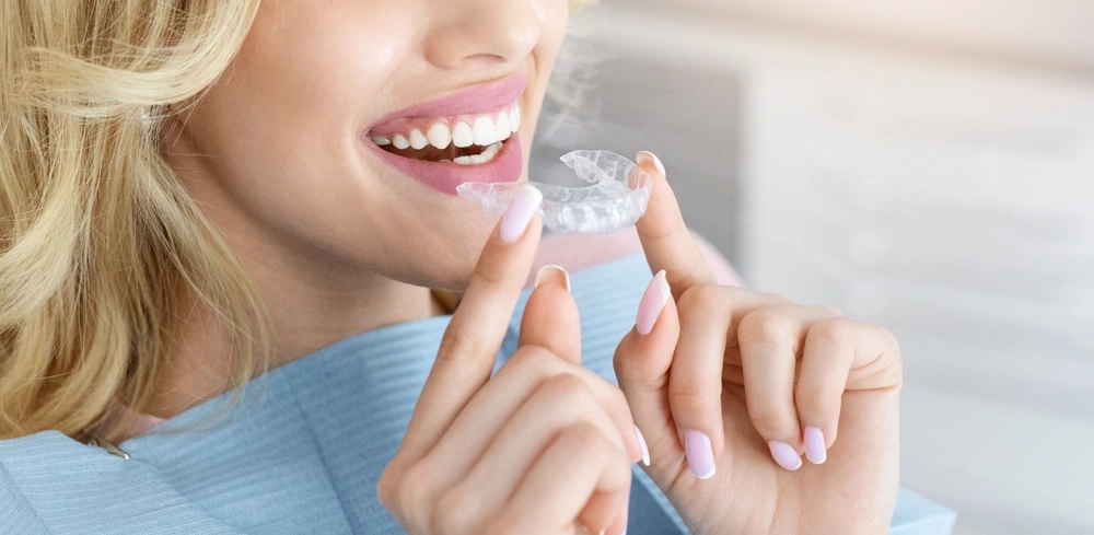 Patient holding a clear Invisalign aligner